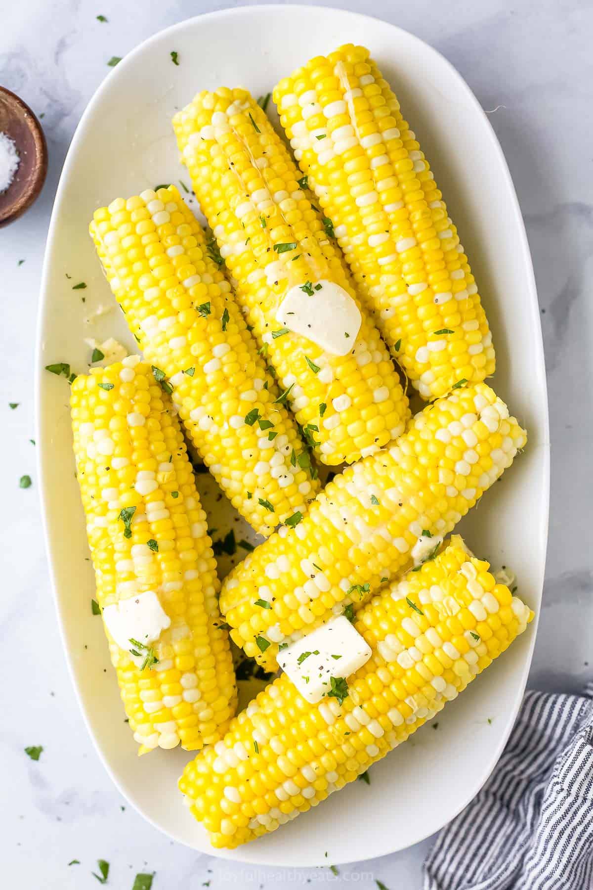 Six ears of Instant Pot corn on the cob with half of them topped with butter