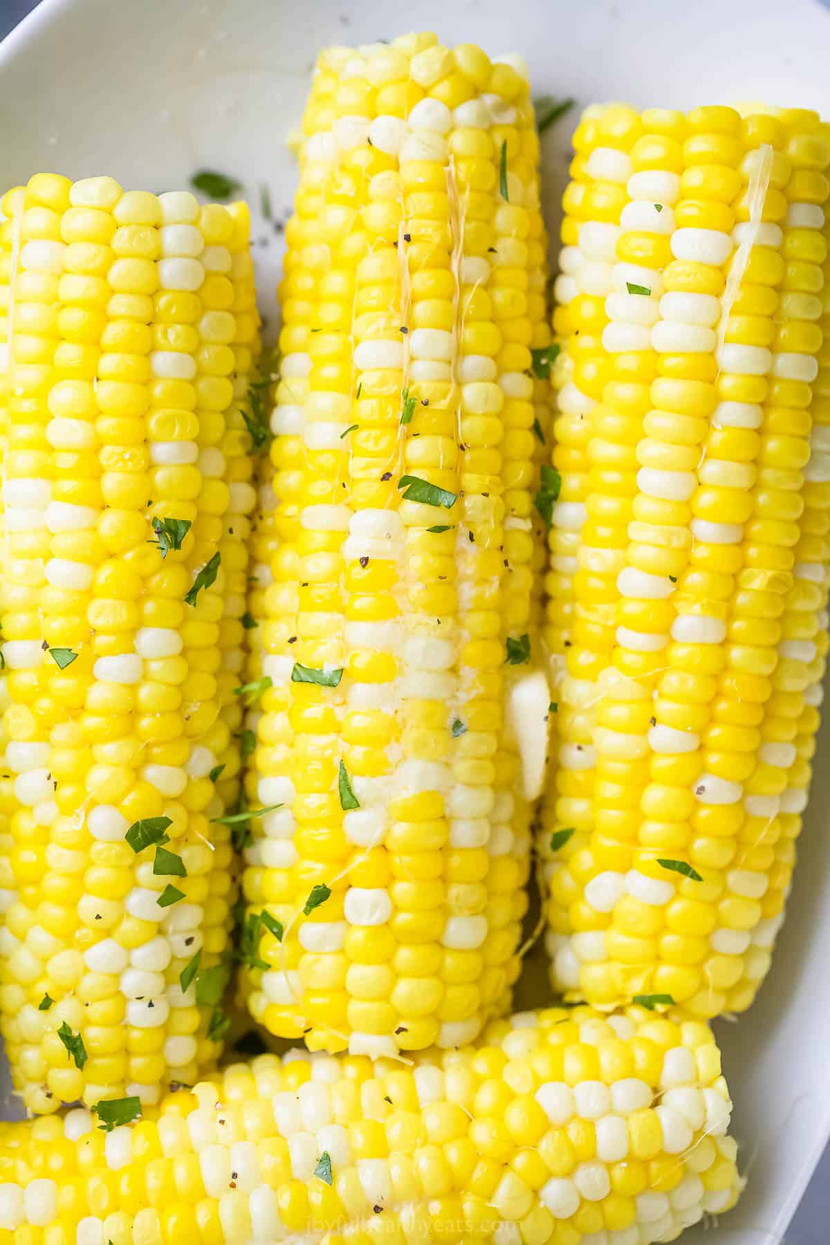 A close-up shot of corn on the cob with a small pat of butter on top