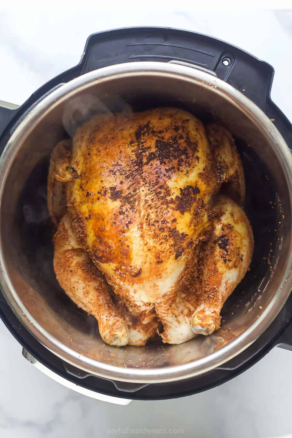 a whole chicken seared in a stainless steel pot