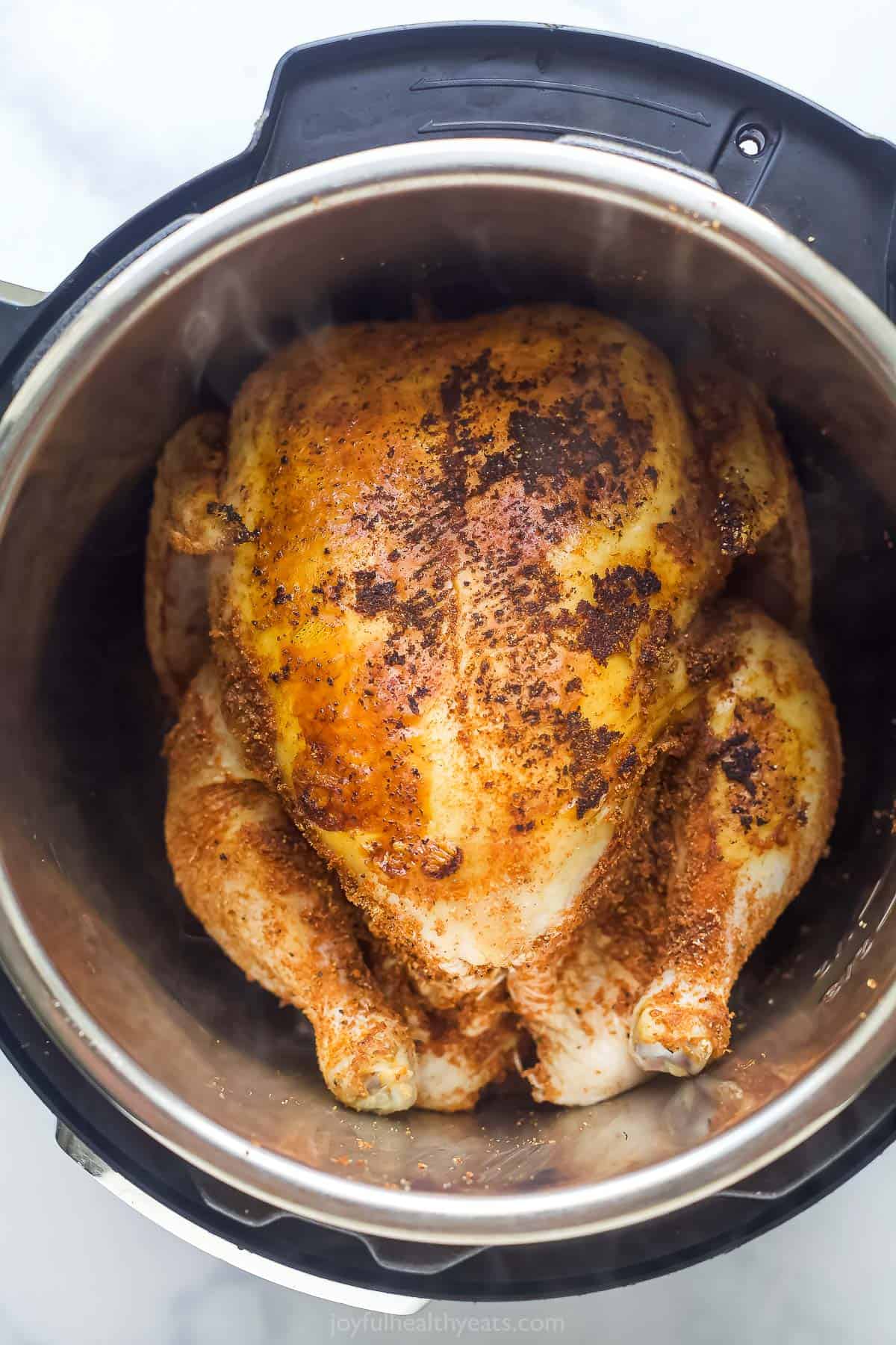 a whole chicken seared in a stainless steel pot