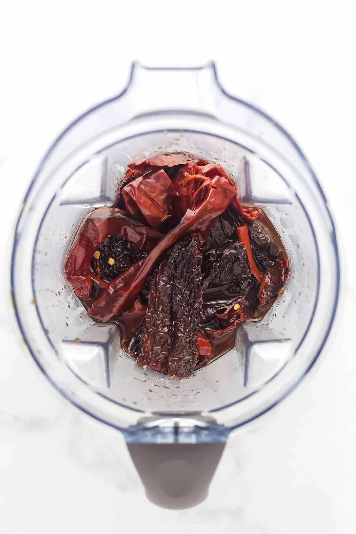 a top view of a blender with dried chilis in it