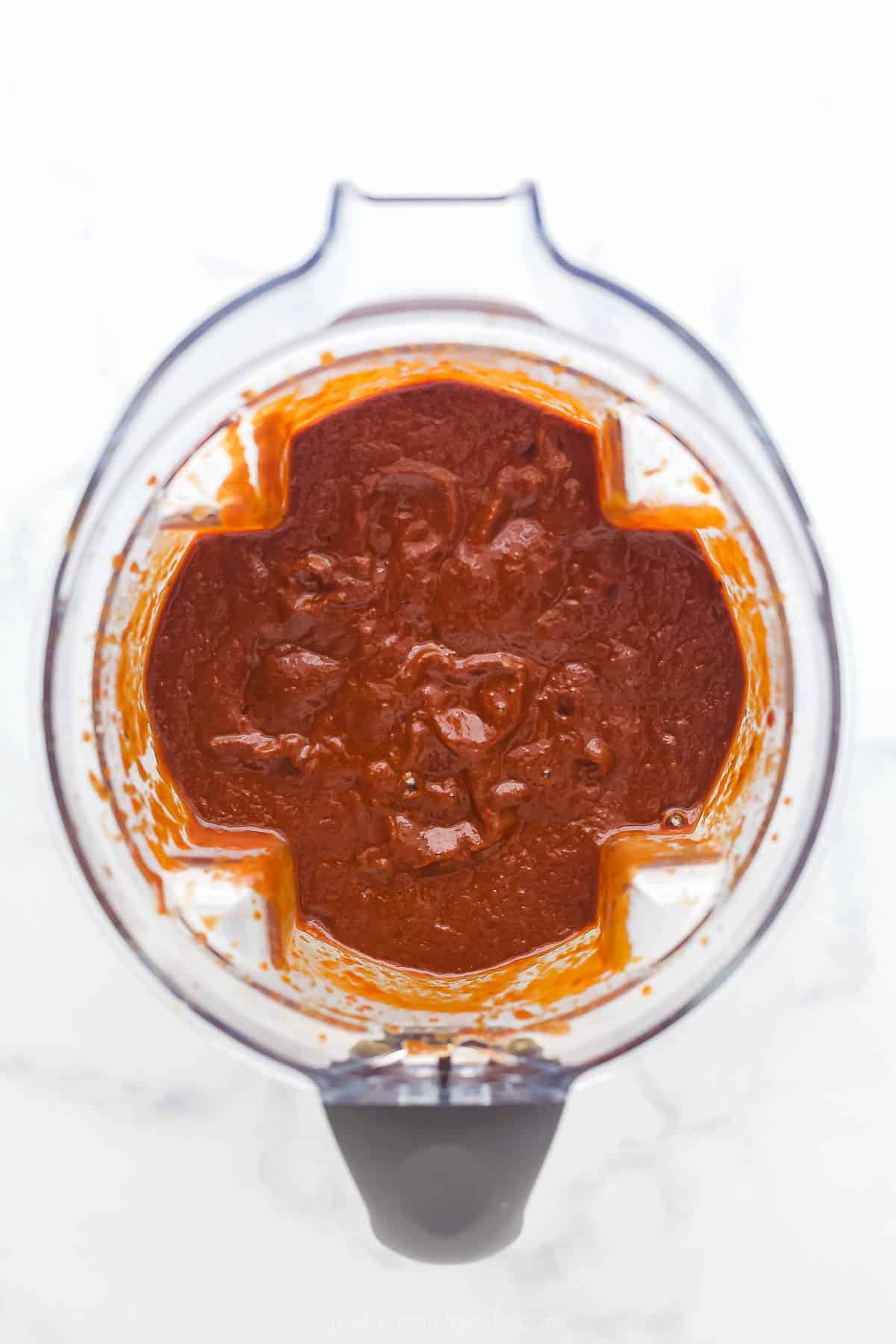 looking into a blender with pureed red sauce