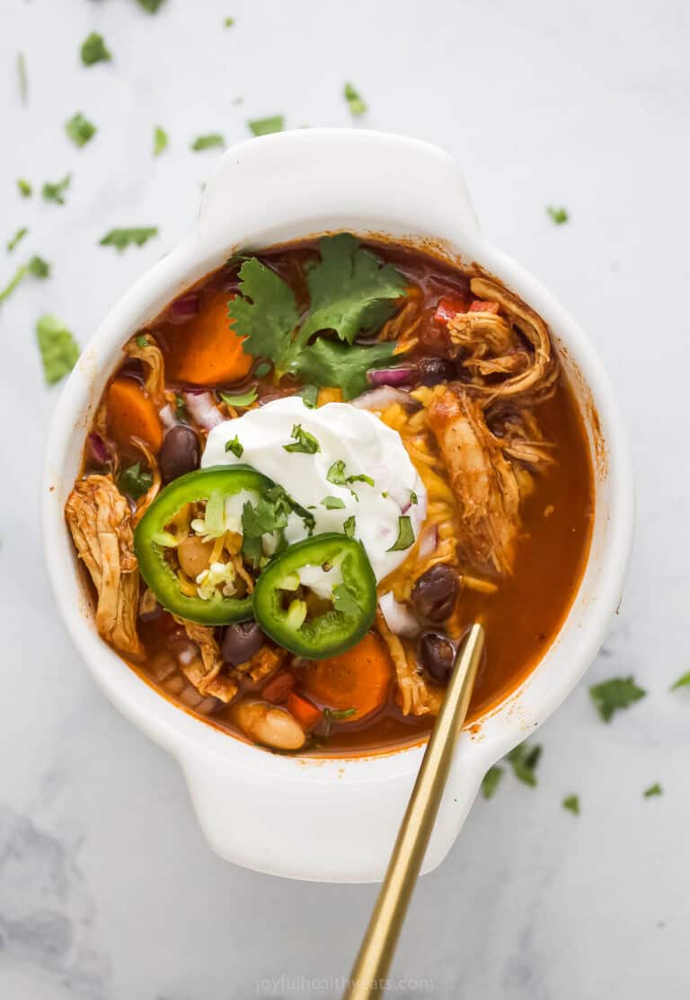 Smoky chicken chili in a white bowl topped with sour cream.