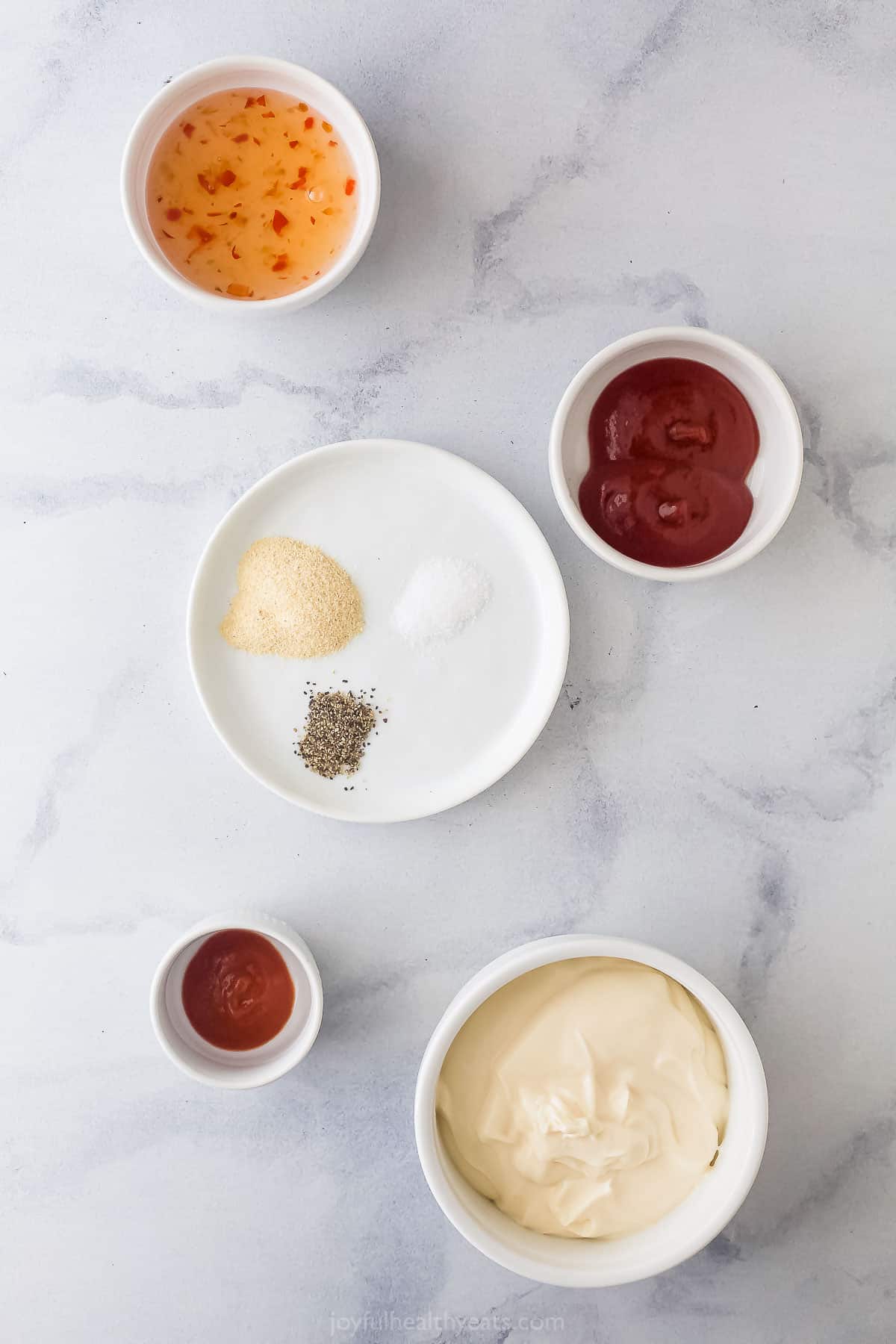 Here's how to make Boom Boom Sauce right at home. This super easy sauce is made with mayo, chili sauce, ketchup, and sriracha. assortment of ingredients in small white prep bowls to make a dipping sauce
