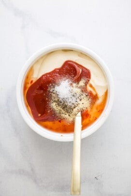 Mayonnaise, ketchup, and spices combined to make a dipping sauce in a small bowl.