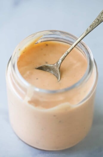 a mason jar with boom boom sauce which is a mayonnaise-based sauce that's sweet, spicy, and tangy.