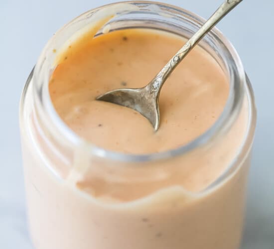 a mason jar with boom boom sauce which is a mayonnaise-based sauce that's sweet, spicy, and tangy.