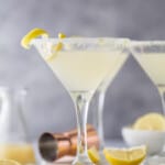 a lemon drop martini with a lemon rind garnish and sugared rim