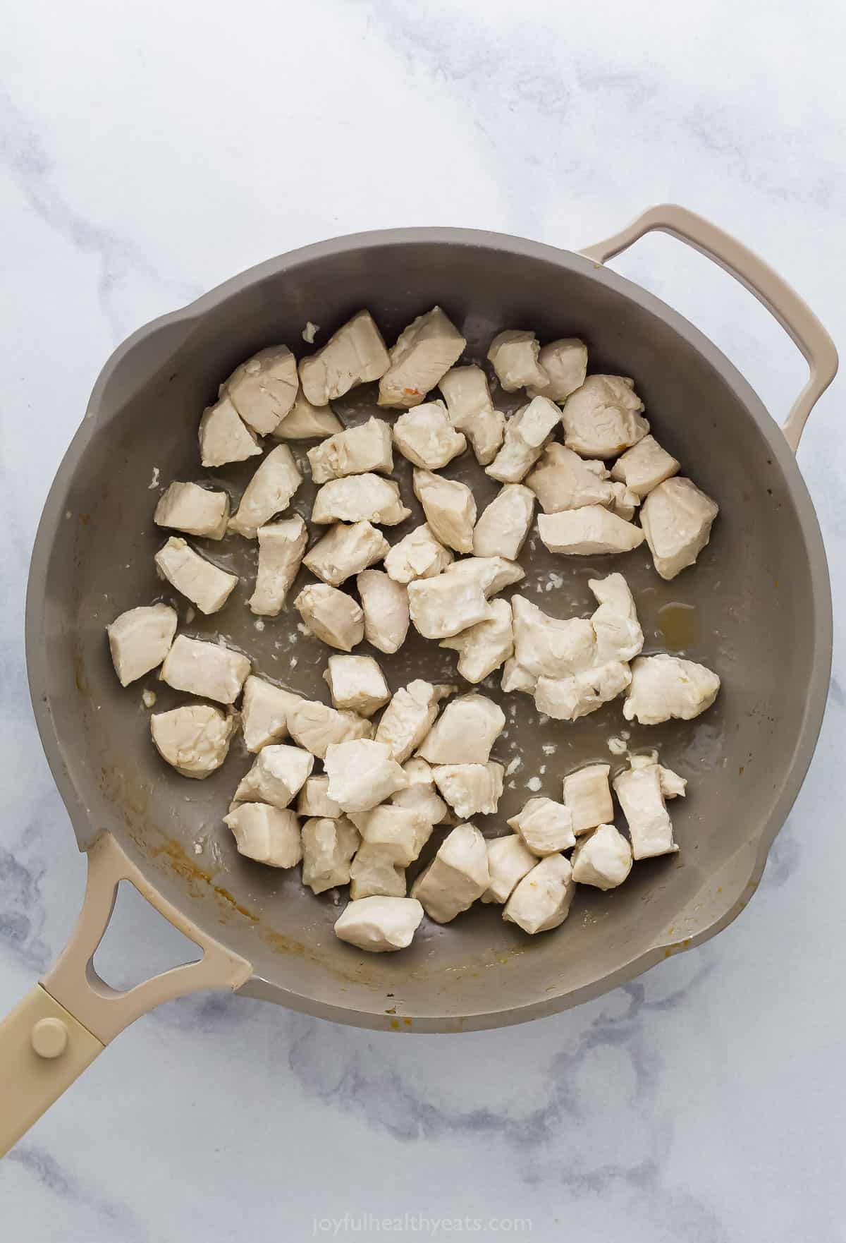 cubed chicken in a saute pan