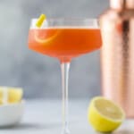 A paper plane cocktail with lemon garnish