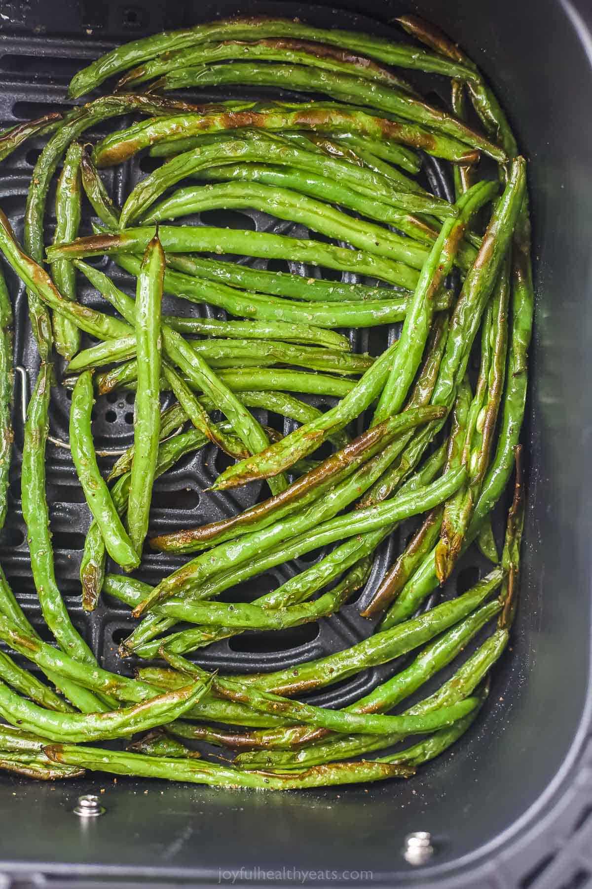 crispy green beans in an air fryer tray