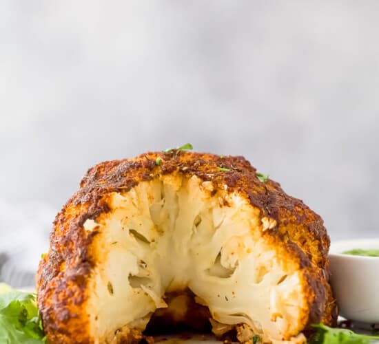 a head of cauliflower that has been roasted with a slice taken out