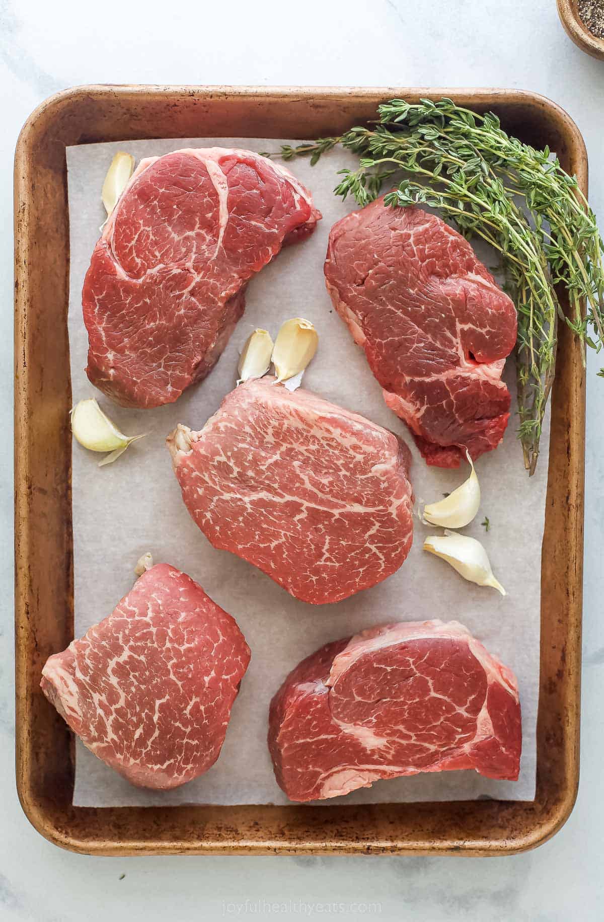 a sheet pan with five filets, garlic, and thyme