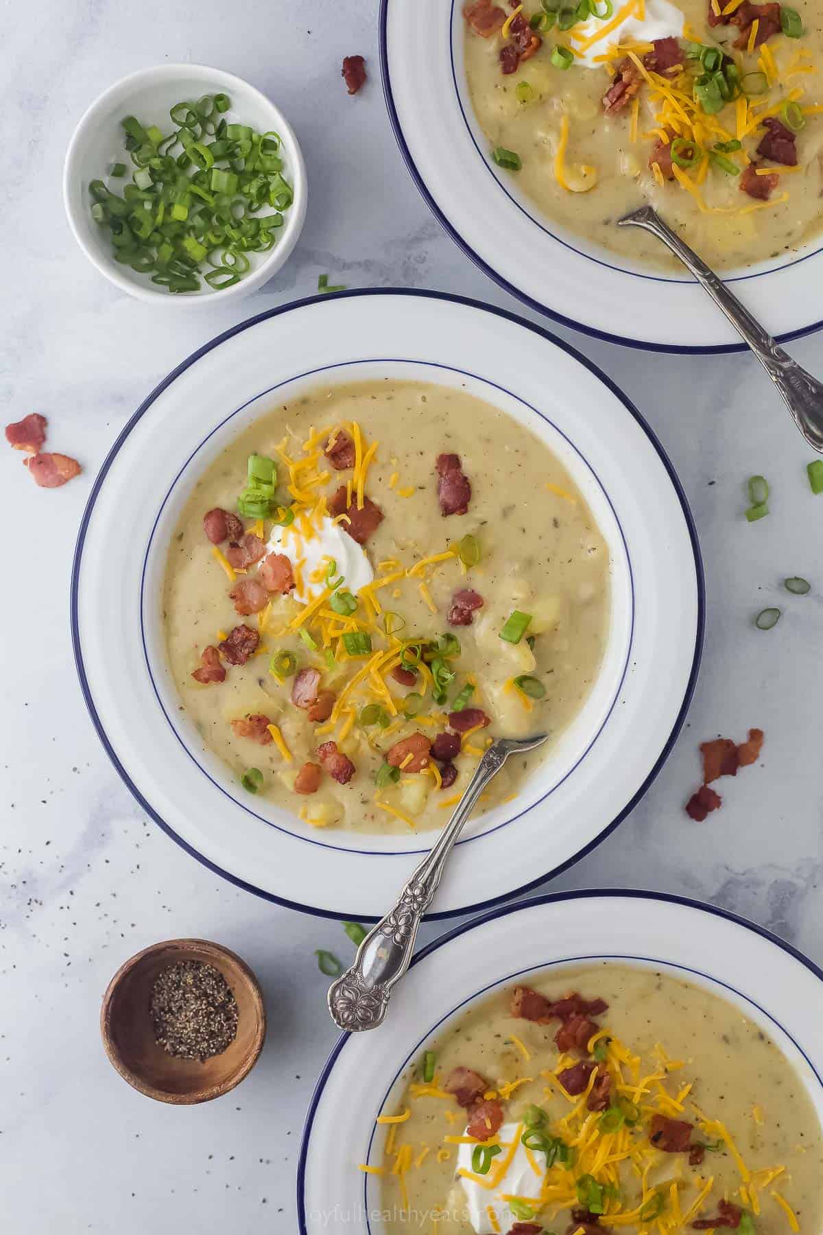 a bowl of creamy potato soup with bacon and cheese garnish