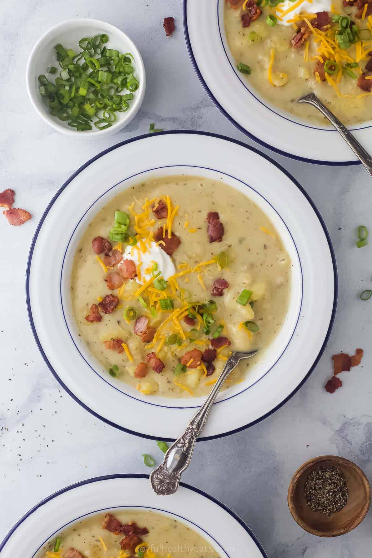 a bowl of creamy ،ato soup with bacon and cheese garnish