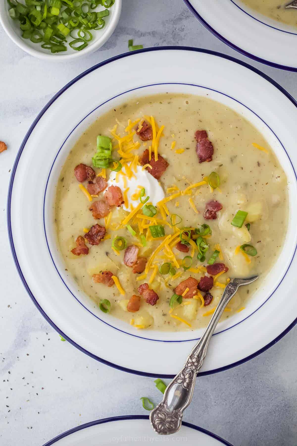 a bowl of creamy ،ato soup with bacon and cheese garnish