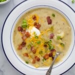 a bowl of creamy ،ato soup with bacon and cheese garnish