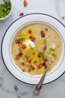 a bowl of creamy potato soup with bacon and cheese garnish