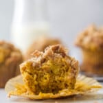 pumpkin muffin on a cupcake liner with a bite taken out of it