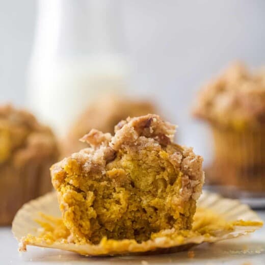 pumpkin muffin on a cupcake liner with a bite taken out of it