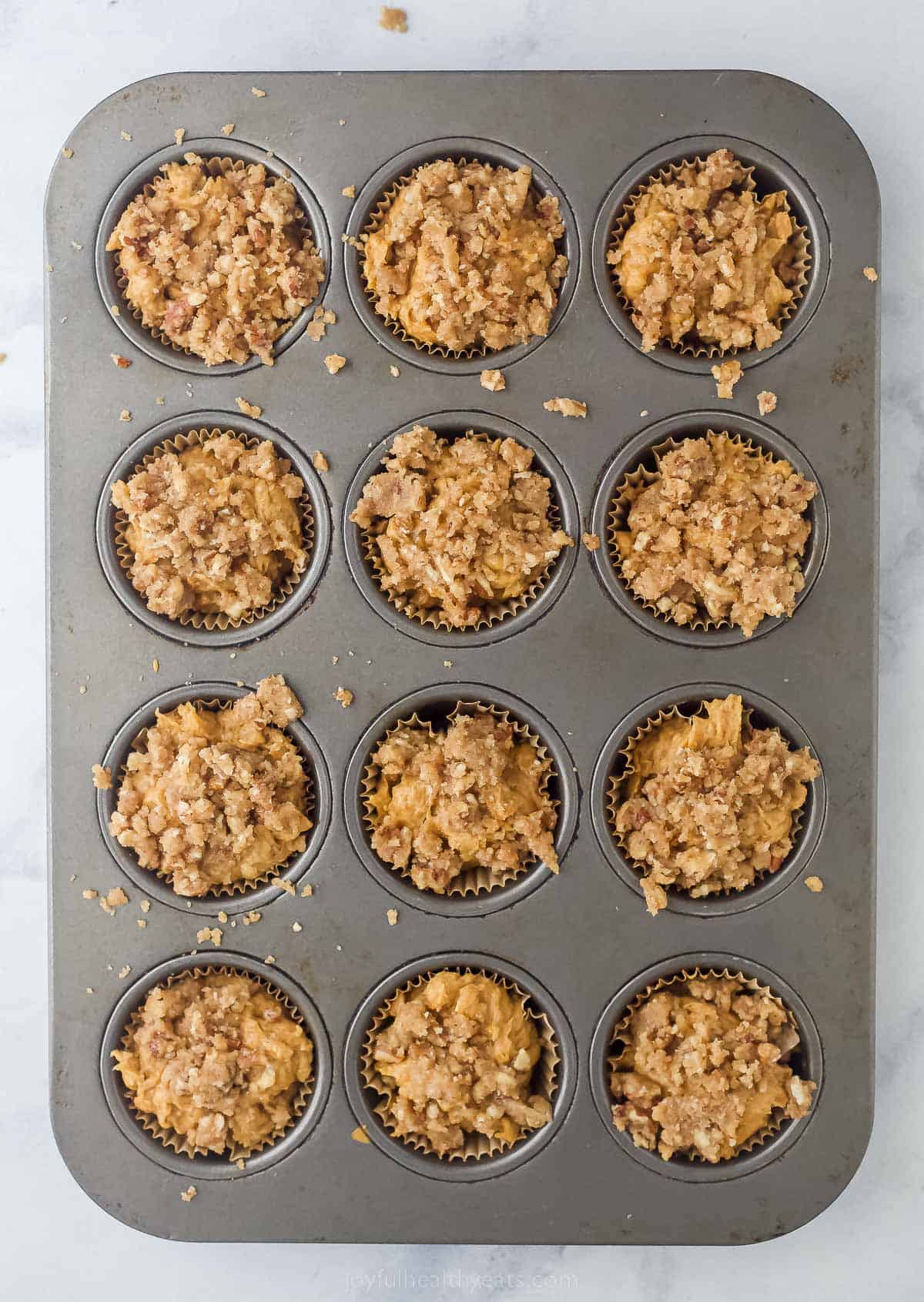 pumpkin muffins with cinnamon streusel in a muffin tin