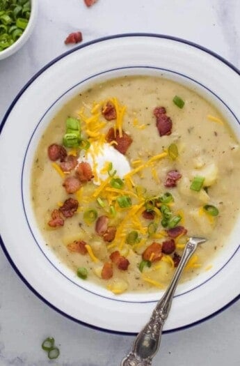 a bowl of creamy potato soup with bacon and cheese garnish