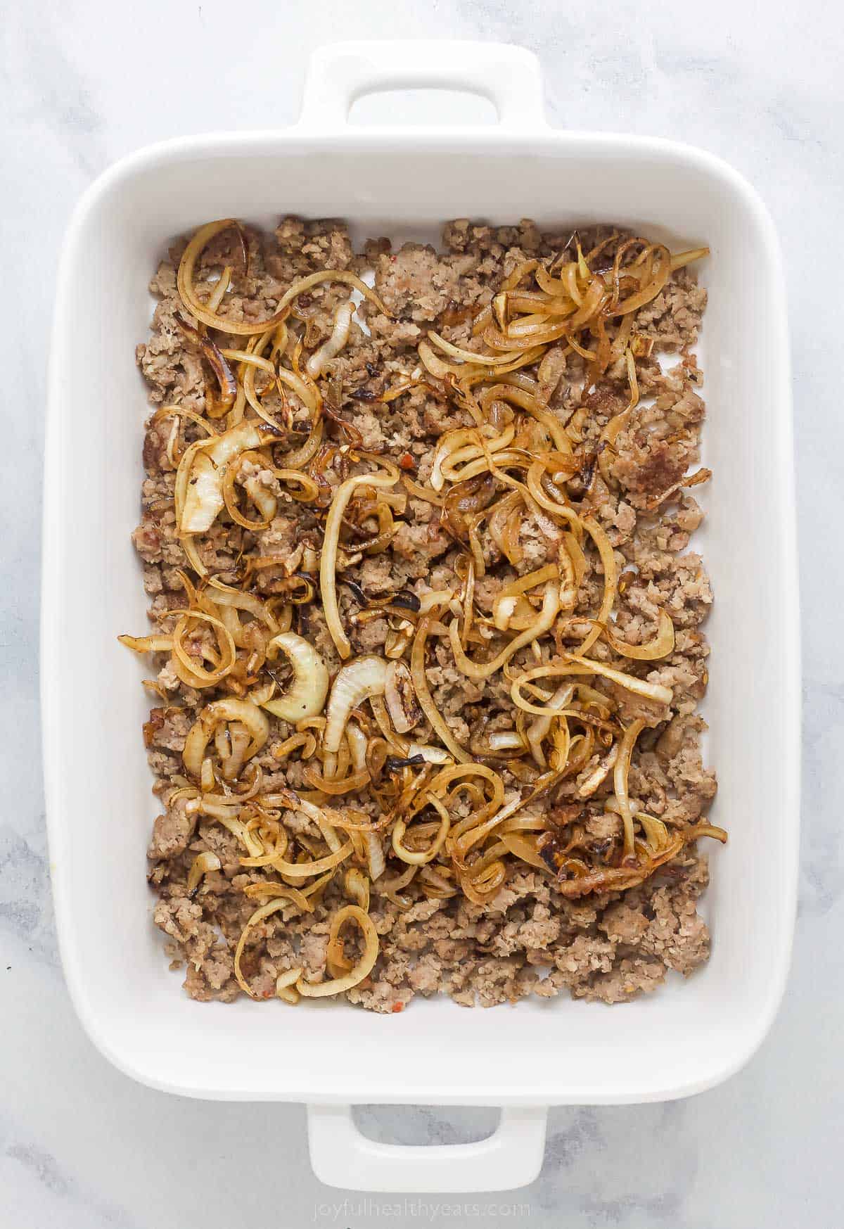 casserole dish with sausage and cooked onions