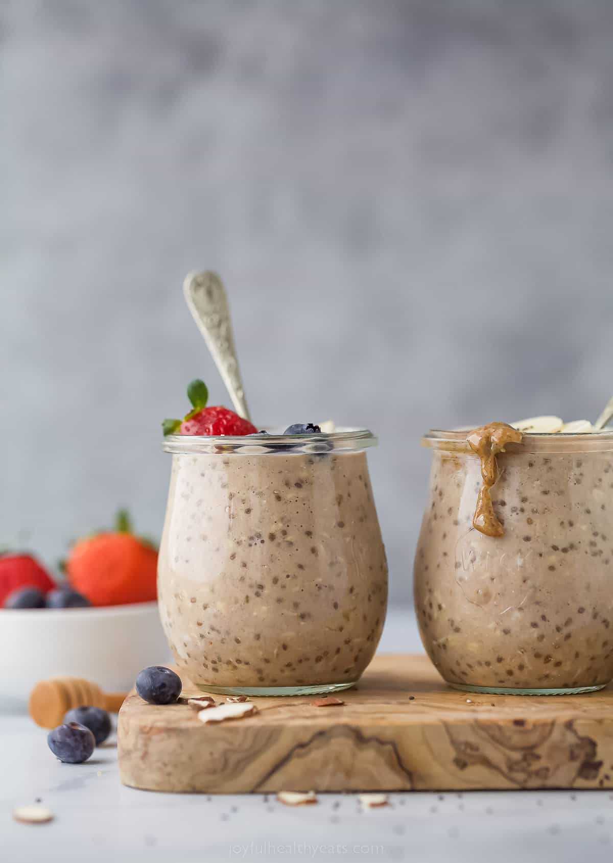 These simple Protein Overnight Oats are a great make-ahead breakfast. These flavorful oats have vanilla protein powder, banana, and cinnamon. two jars with protein overnight oats and berry and banana garnish