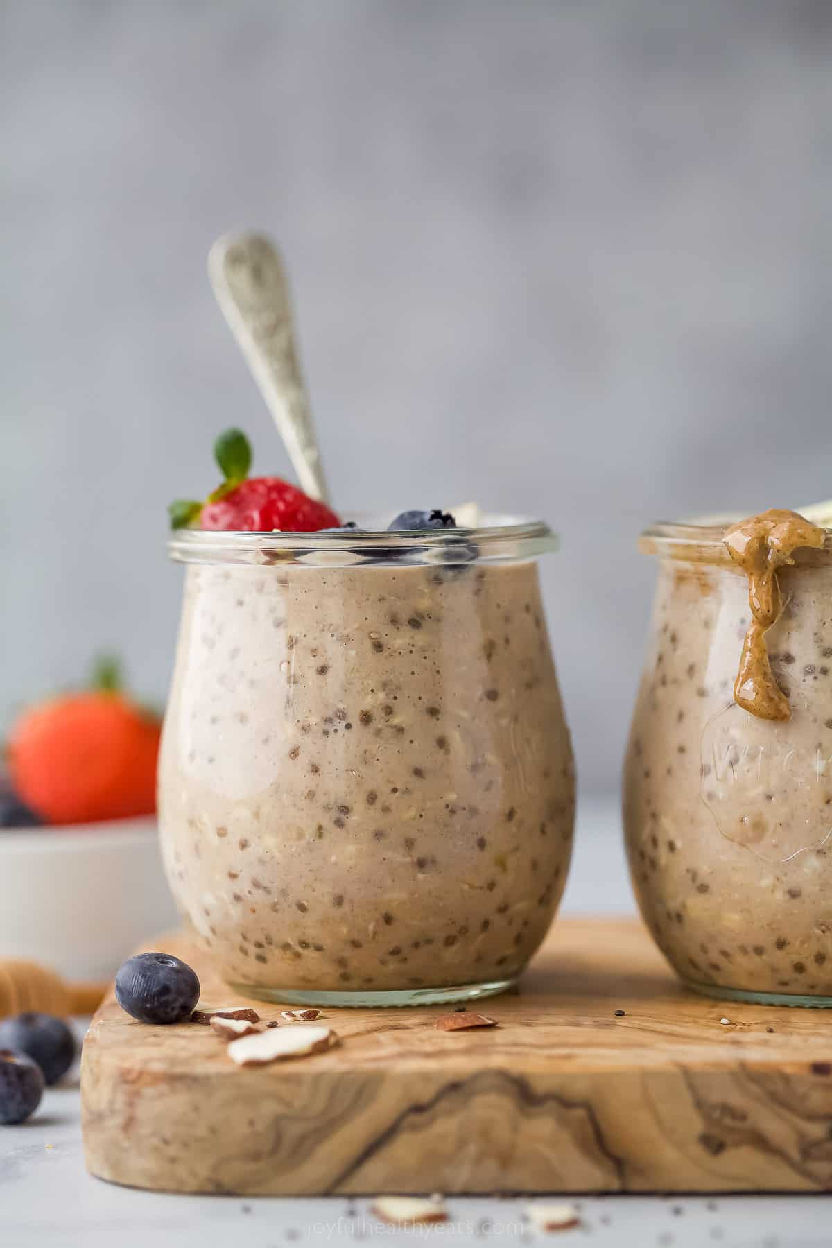 These simple Protein Overnight Oats are a great make-ahead breakfast. These flavorful oats have vanilla protein powder, banana, and cinnamon. a jar with cooked oats and a strawberry garnish