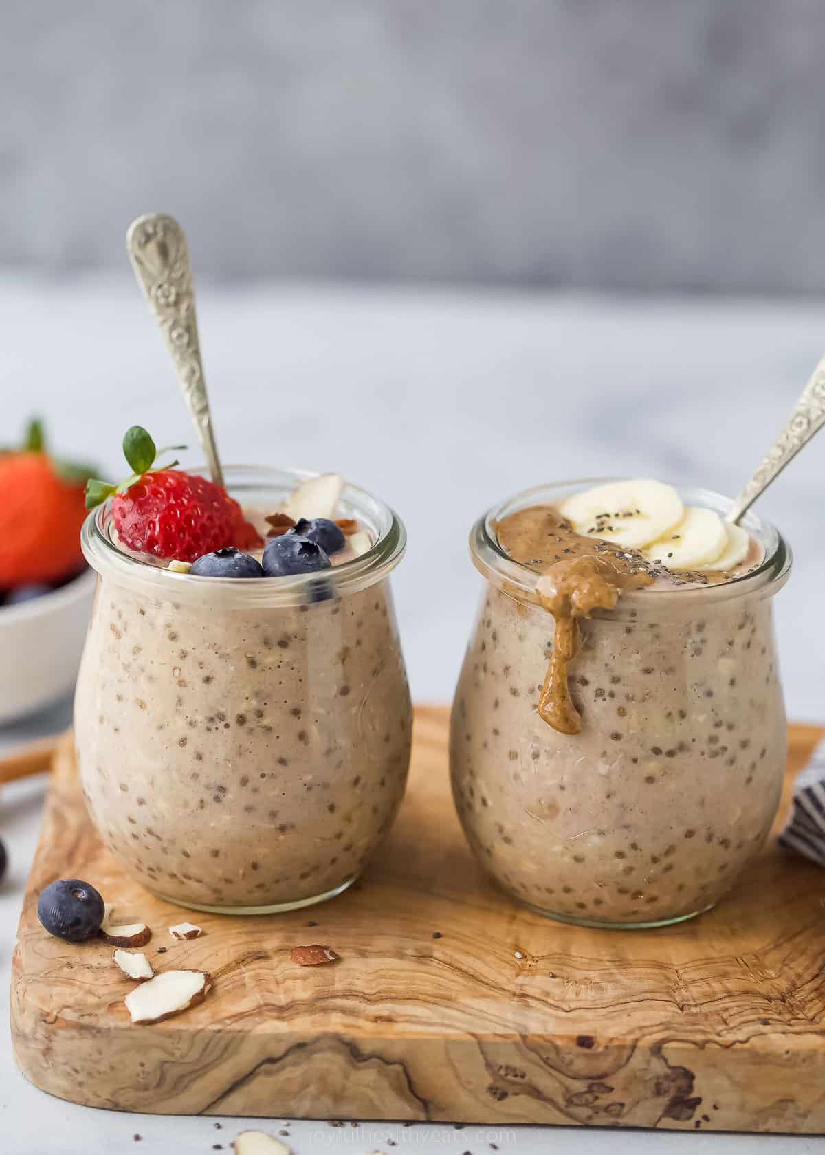 These simple Protein Overnight Oats are a great make-ahead breakfast. These flavorful oats have vanilla protein powder, banana, and cinnamon. two jars with protein overnight oats and berry and banana garnish
