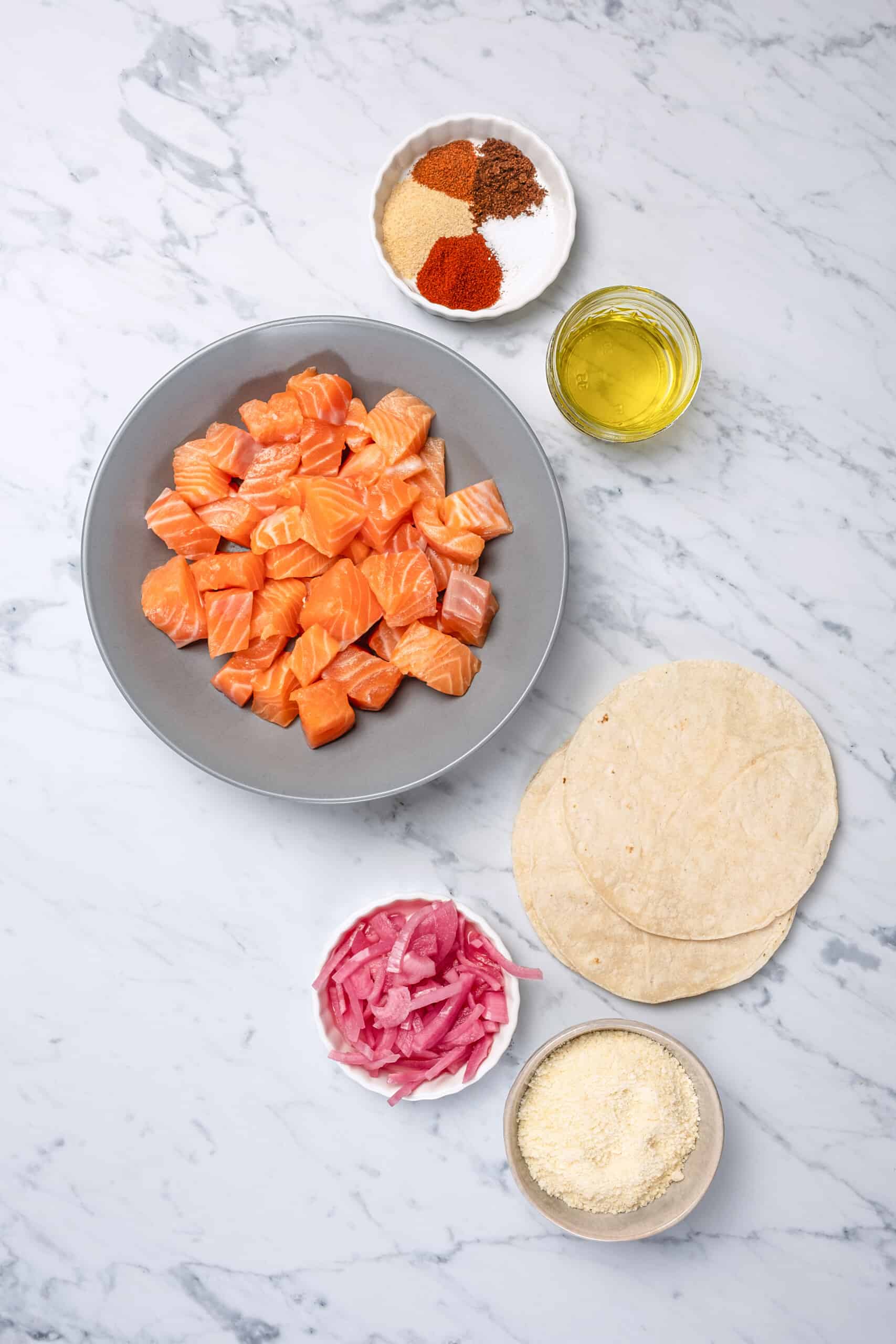 These Easy Salmon Tacos are topped with creamy slaw, pickled onions, and cotija cheese. They are flavorful, healthy, and ready in 30 minutes! ingredients to make salmon tacos