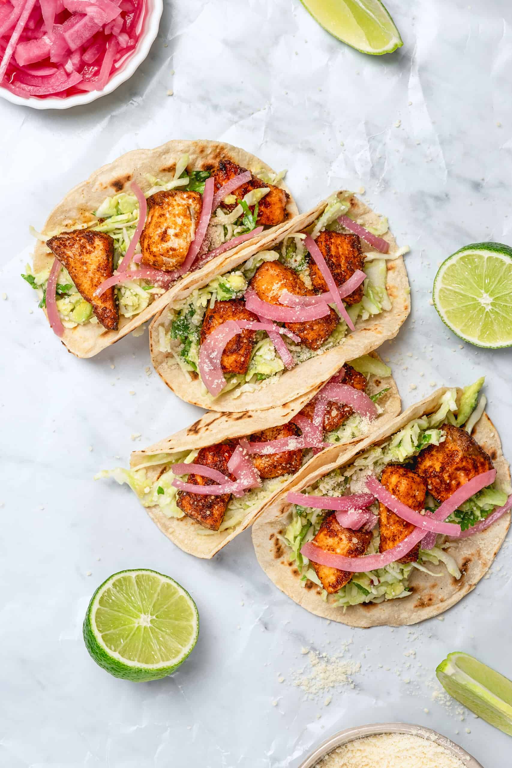 salmon tacos with creamy sauce and red onion garnish