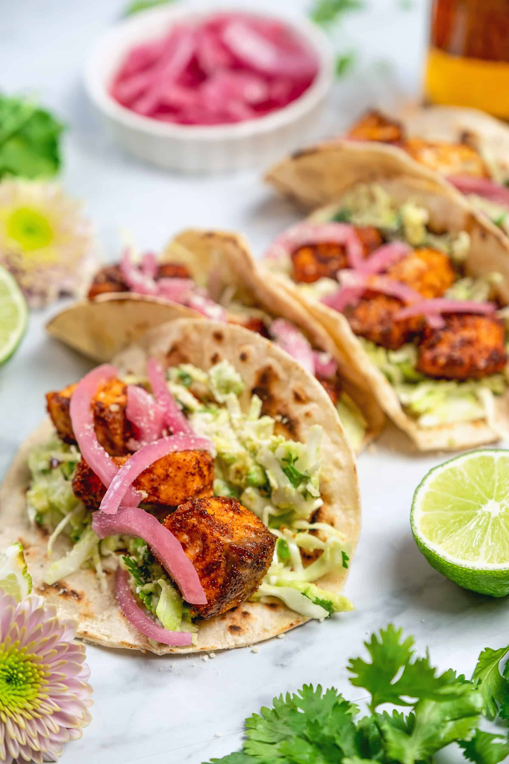 easy salmon tacos with creamy sauce and red onion garnish