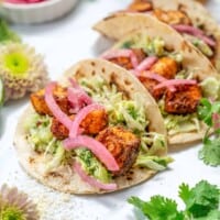 easy salmon tacos with creamy sauce and red onion garnish