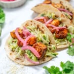 easy salmon tacos with creamy sauce and red onion garnish