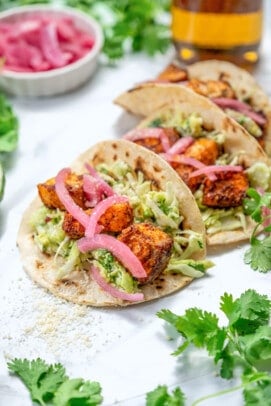 easy salmon tacos with creamy sauce and red onion garnish