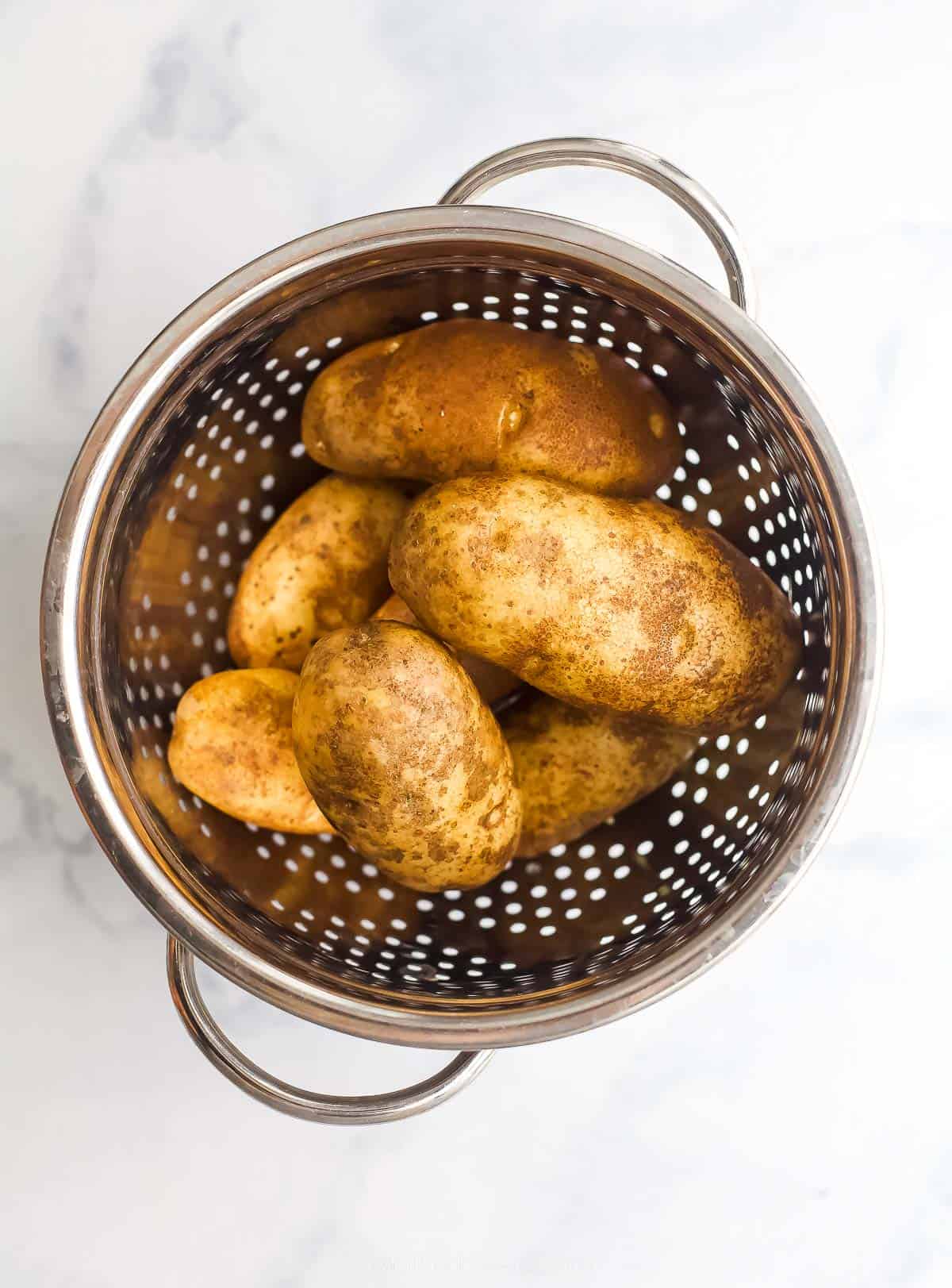 a collander with whole potatoes