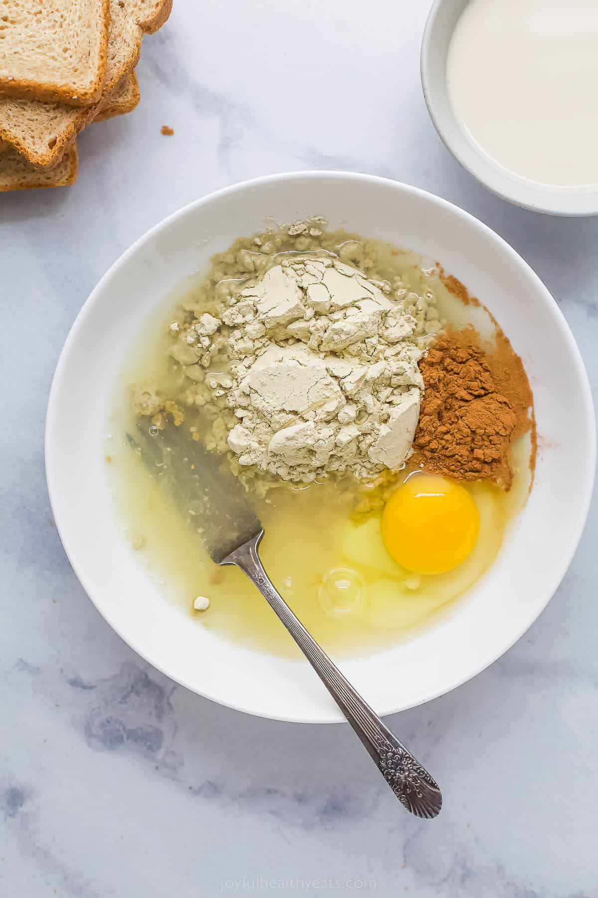 a bowl with protein powder, egg, oat milk, and cinnamon