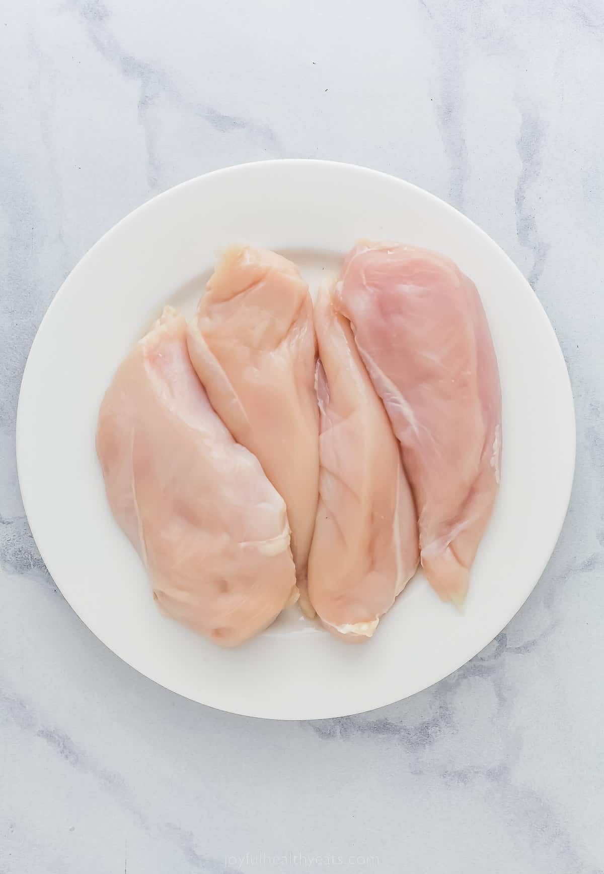 four raw chicken breasts