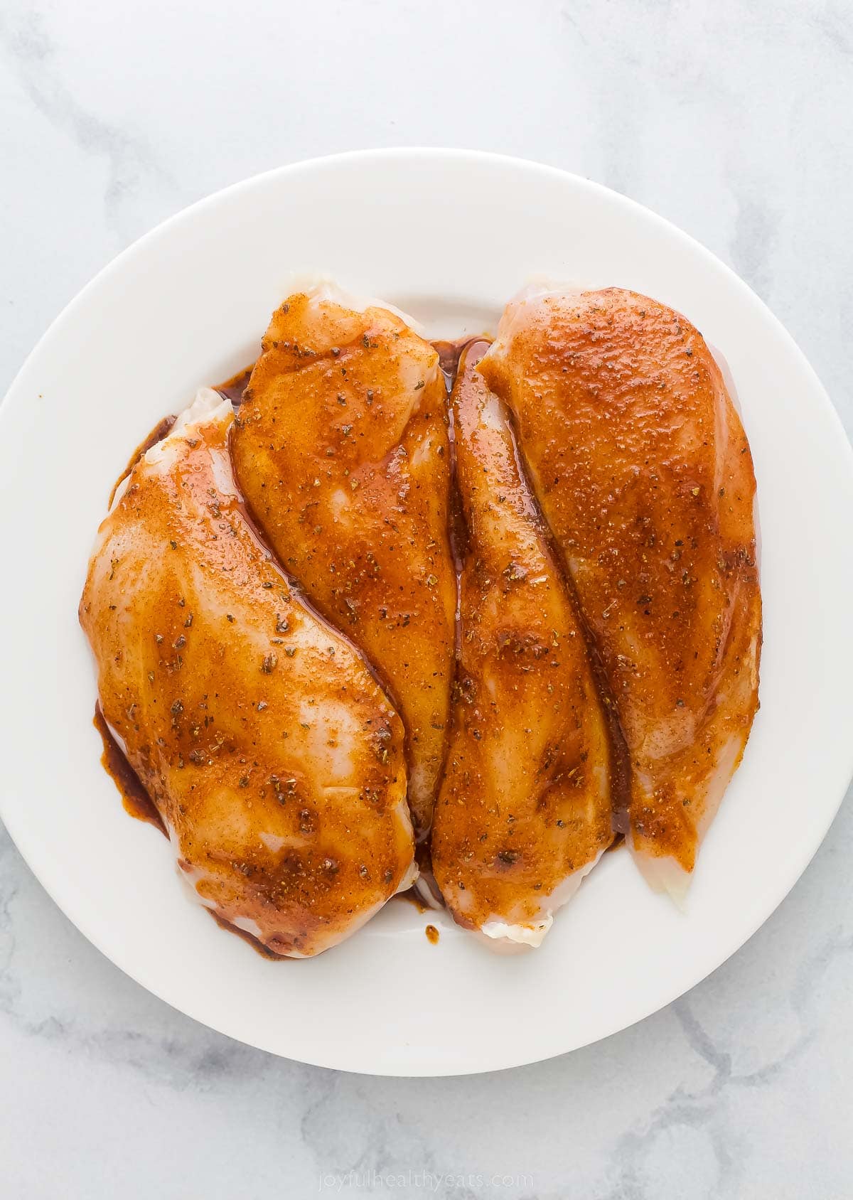 four seasoned chicken breasts on a plate