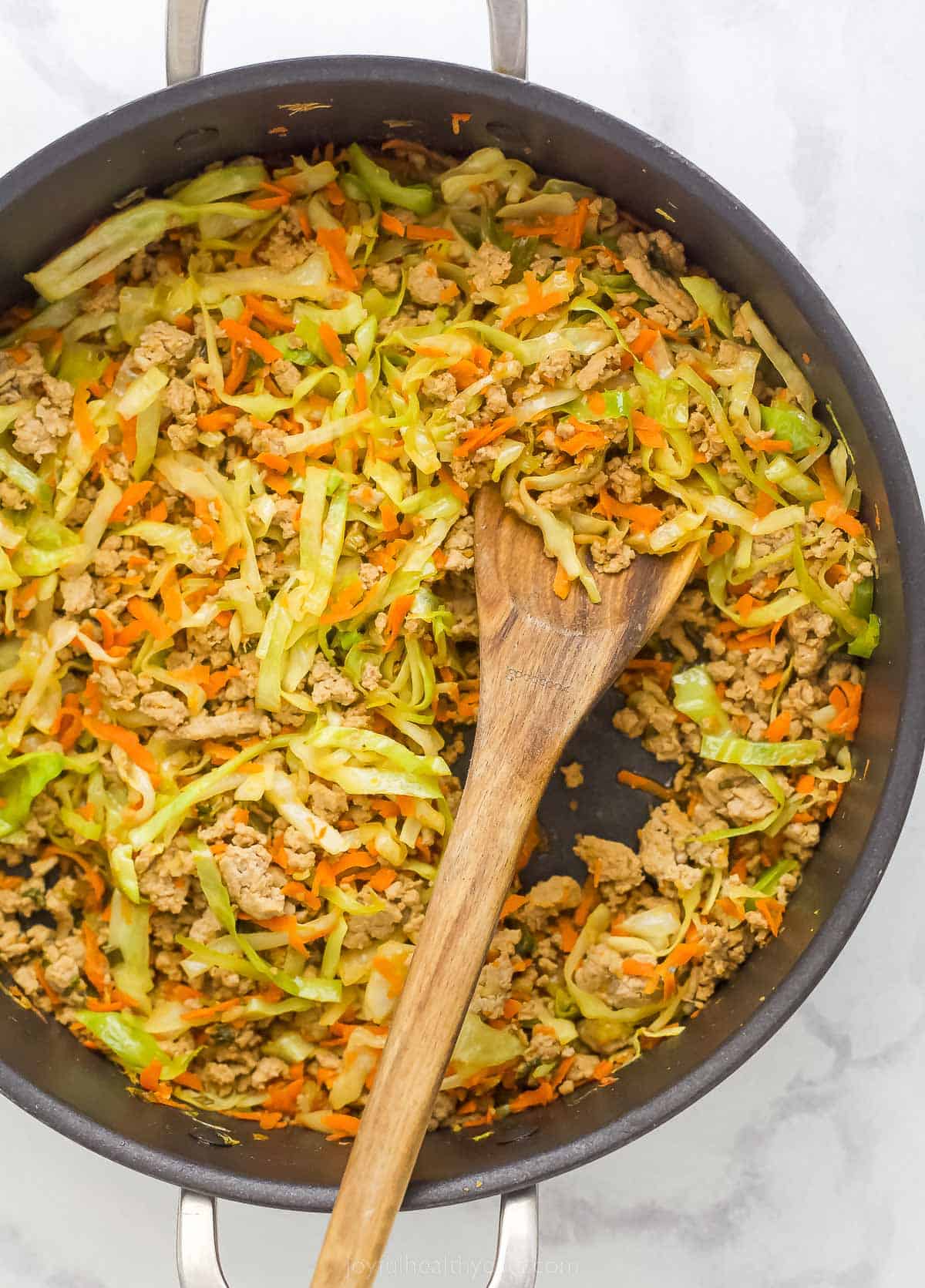 egg roll in a bowl ingredients in a pan like ground turkey, cabbage, and carrots