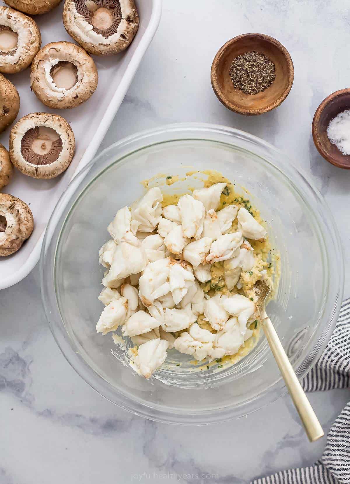 adding crab to a bowl to make the filling for quick stuffed mushrooms