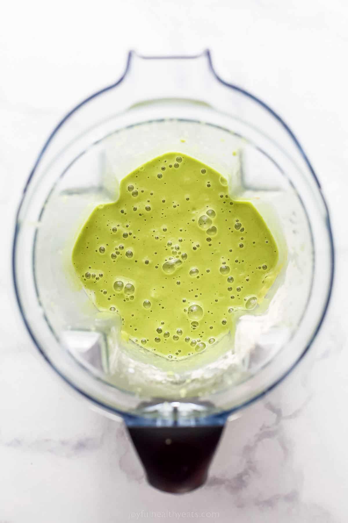 top view of a blender with a green smoothie in it