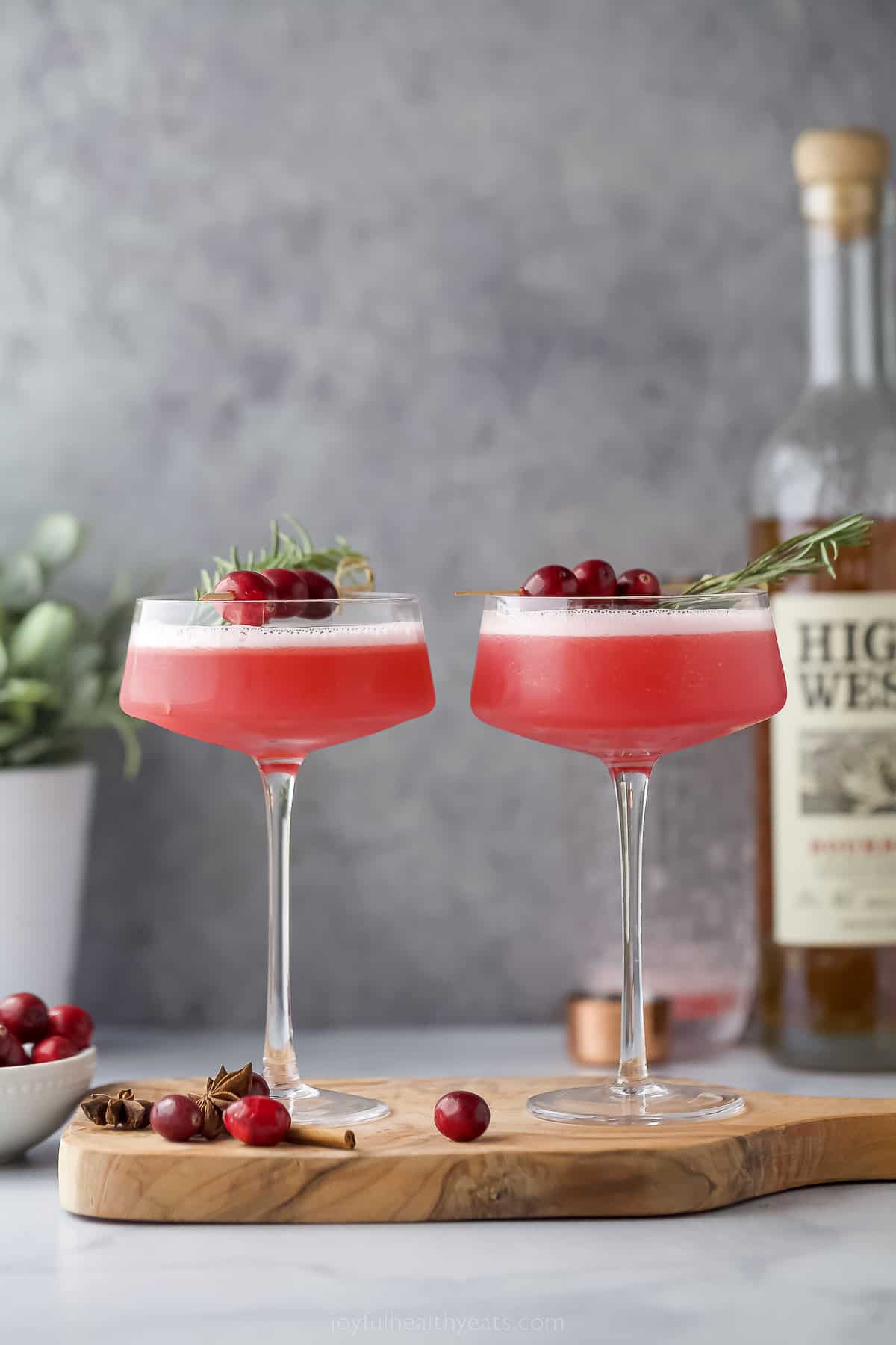 two glasses filled with spiced cranberry whiskey sour