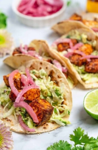 easy salmon tacos with creamy sauce and red onion garnish