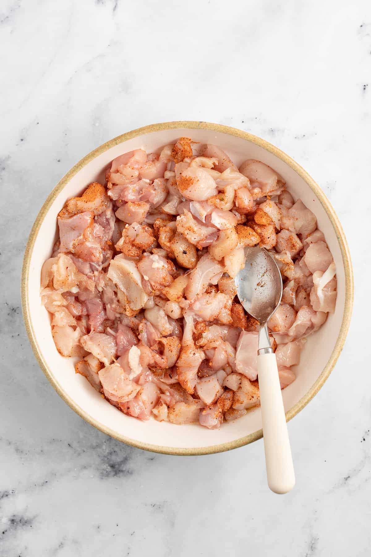 cooking bites of chicken in a saute pan that have been seasoned with ،es