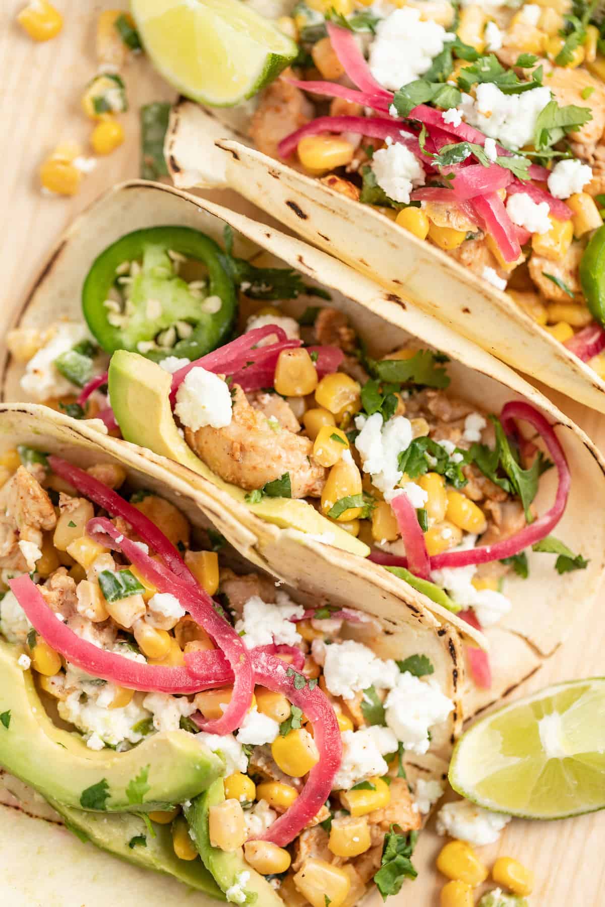 a display of chicken street corn tacos on a board