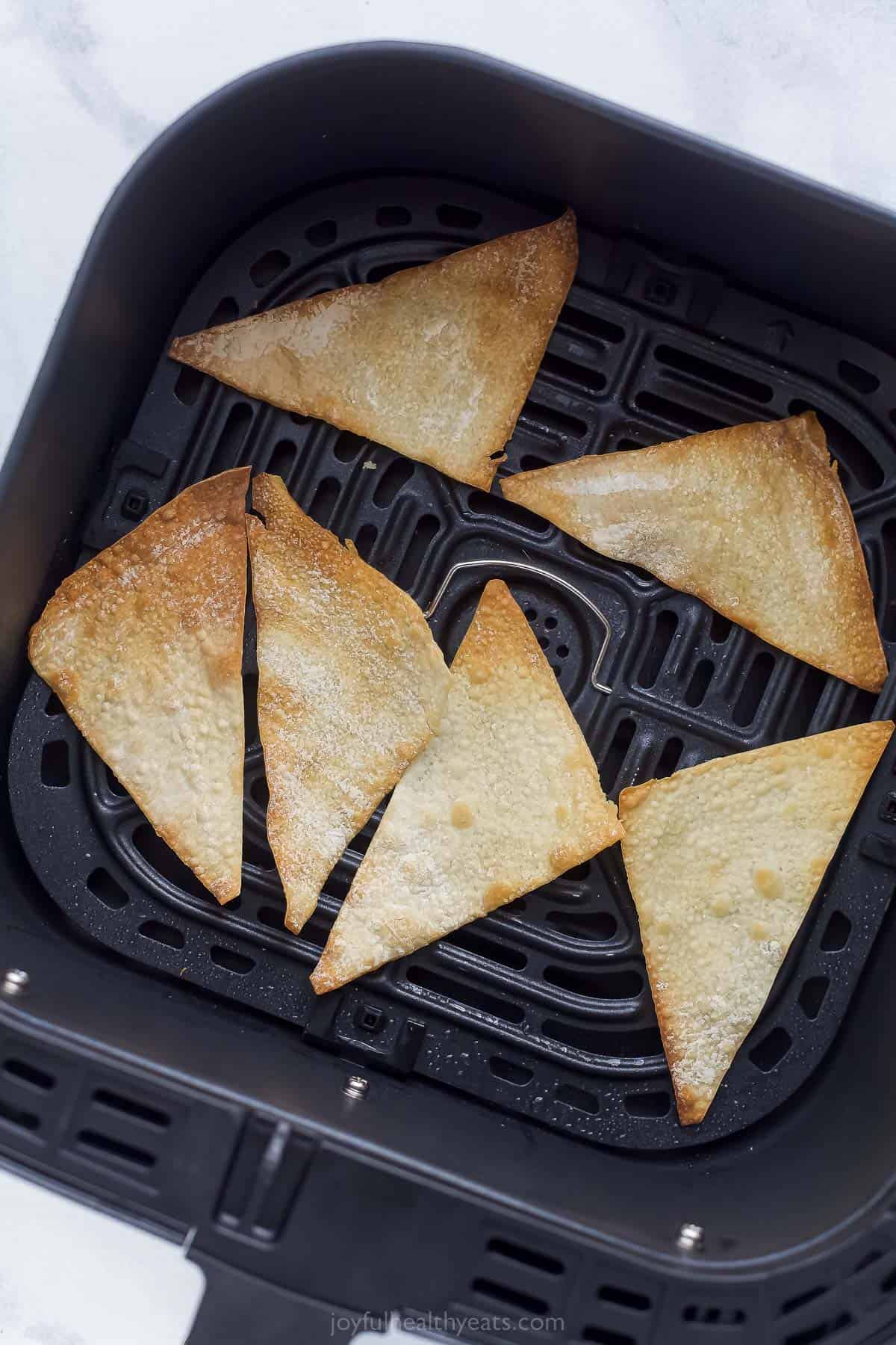wonton triangles in an air fryer basket