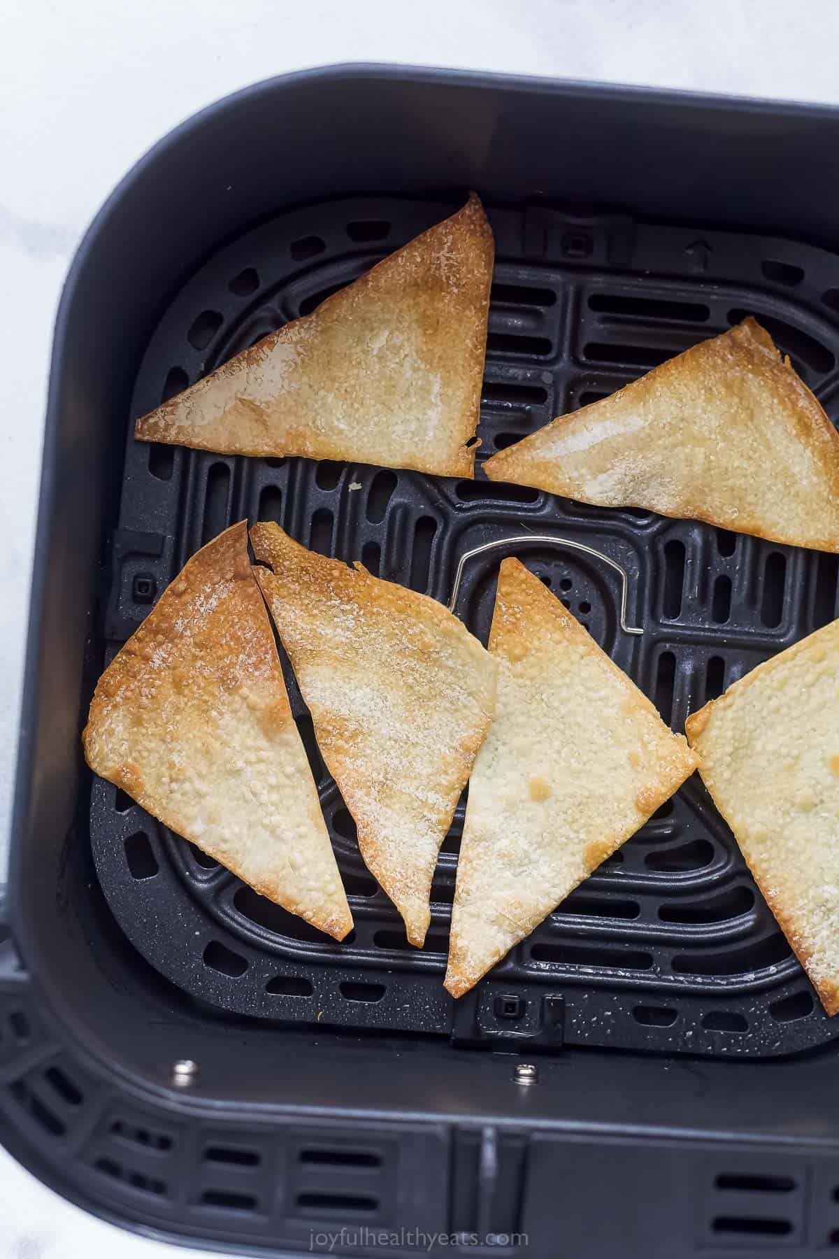 wonton triangles in an air fryer basket