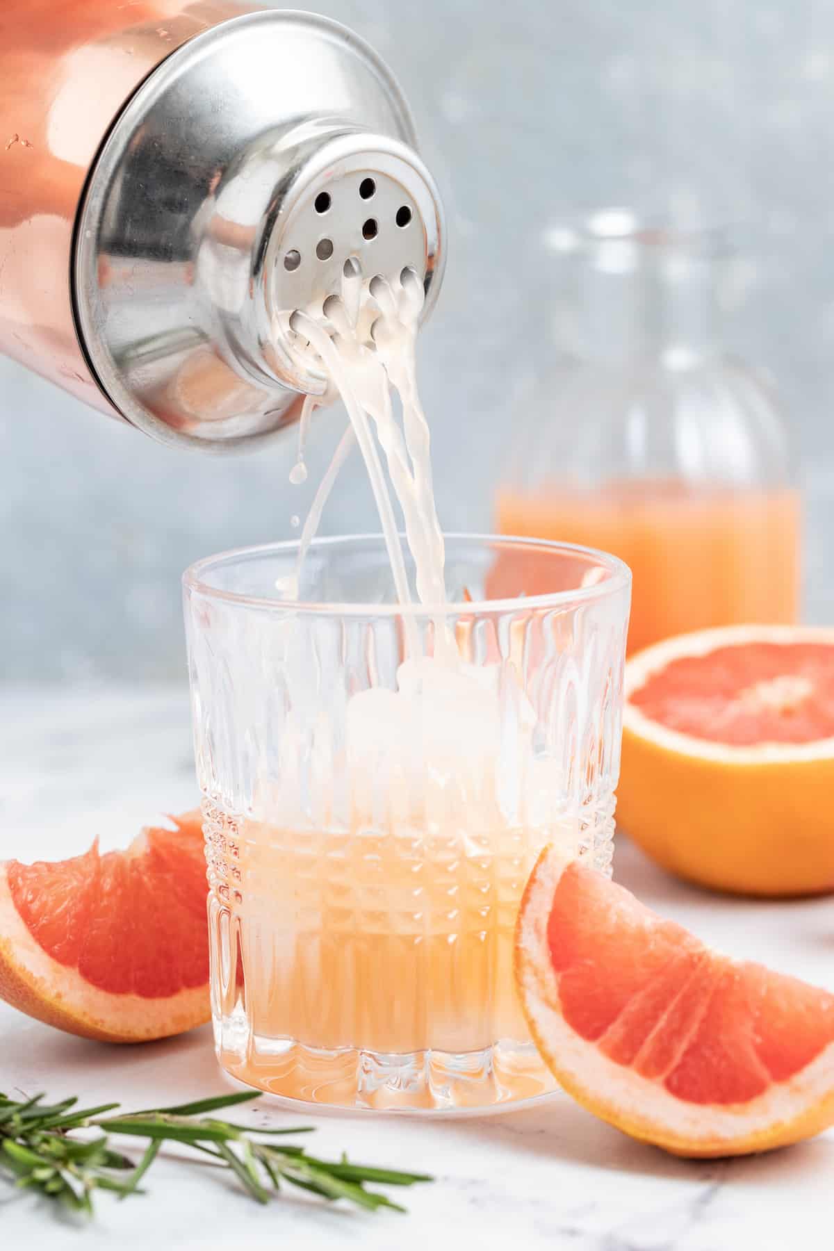 pouring a greyhound cocktail which is fresh grapefruit juice and vodka
